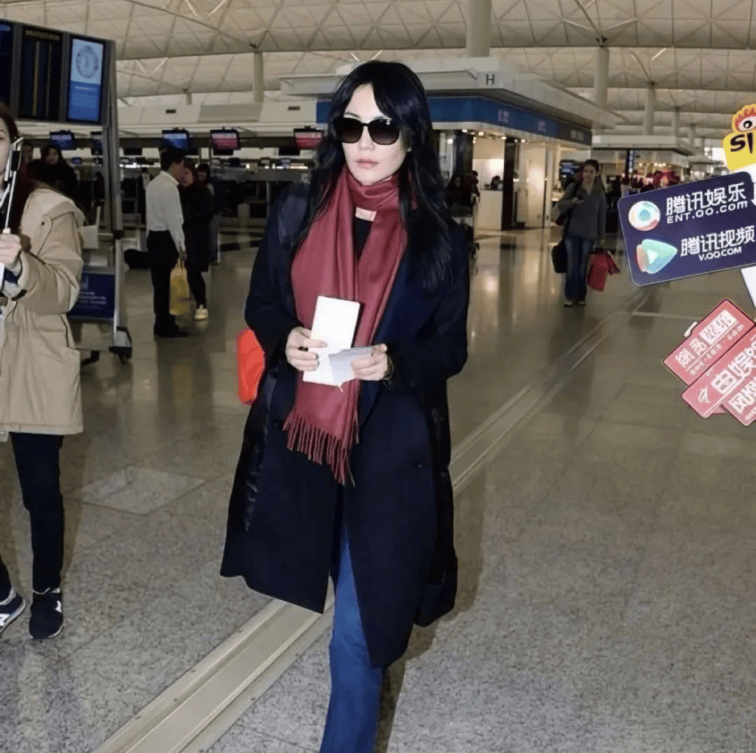 原创            55岁王菲走机场真任性！穿黑羽绒服配大红围脖，不仅不土气反而时髦高级！