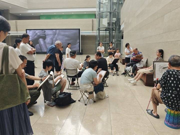 西湖边有个老年写生团，周末免费给游客画肖像