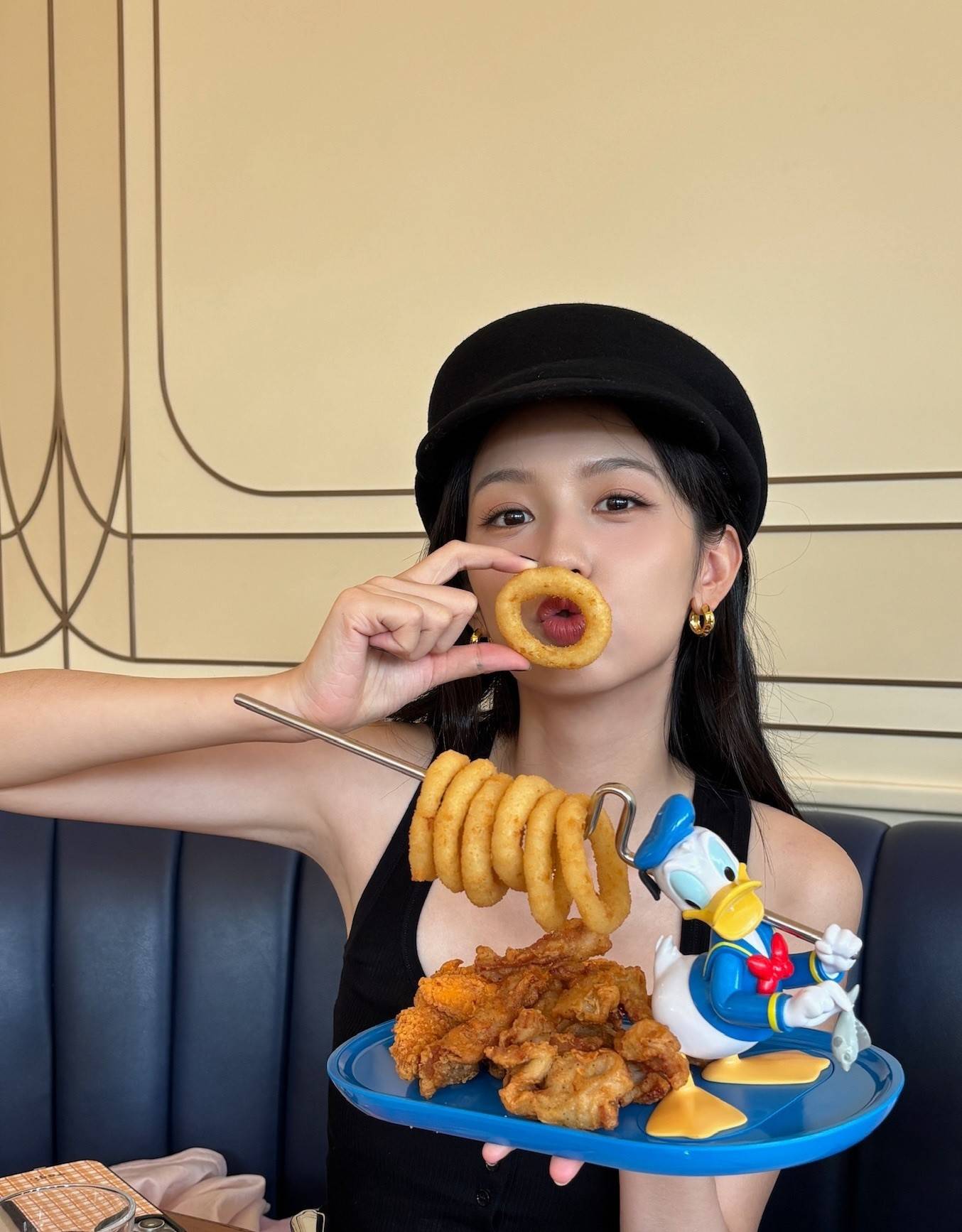 周也打扮随性开心游玩迪士尼 手捧唐老鸭托盘可爱撅嘴