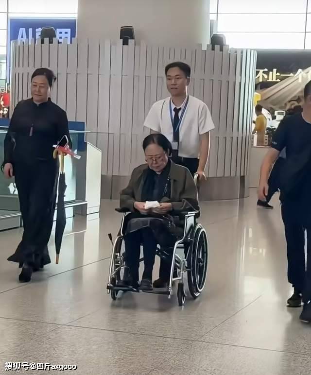 原创            斯琴高娃坐轮椅现身机场，脸部松弛法令纹明显，身体状况让人担忧