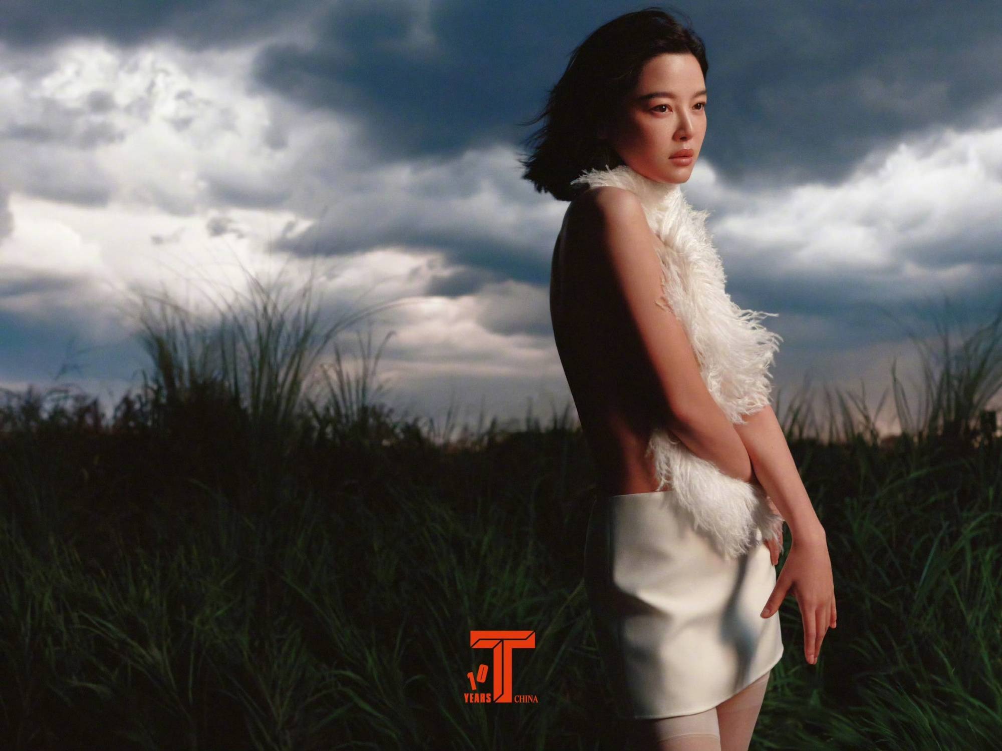辛芷蕾穿白色套装立于草地上 短发随风飞舞气质迷人