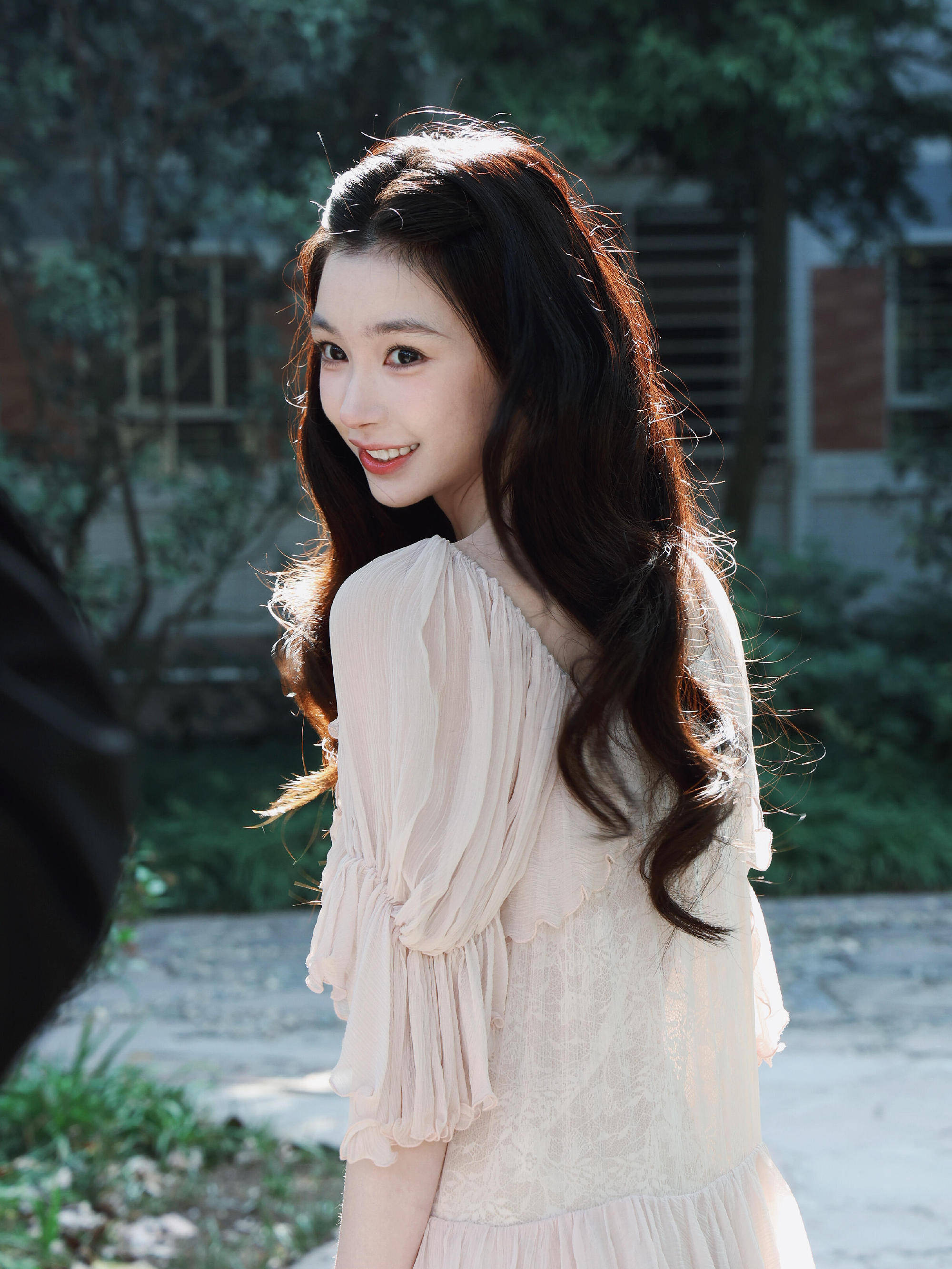 易梦玲穿粉色纱裙配卷发温柔娇俏 逆光下回眸浅笑甜美灵动