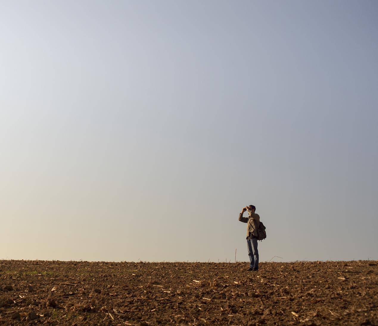 在野外的人用双筒望远镜看